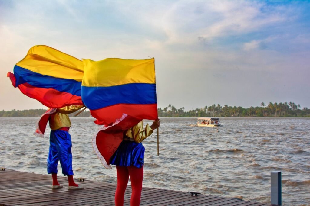 vibrant colombian flags waving over a scenic river with colorful costumes