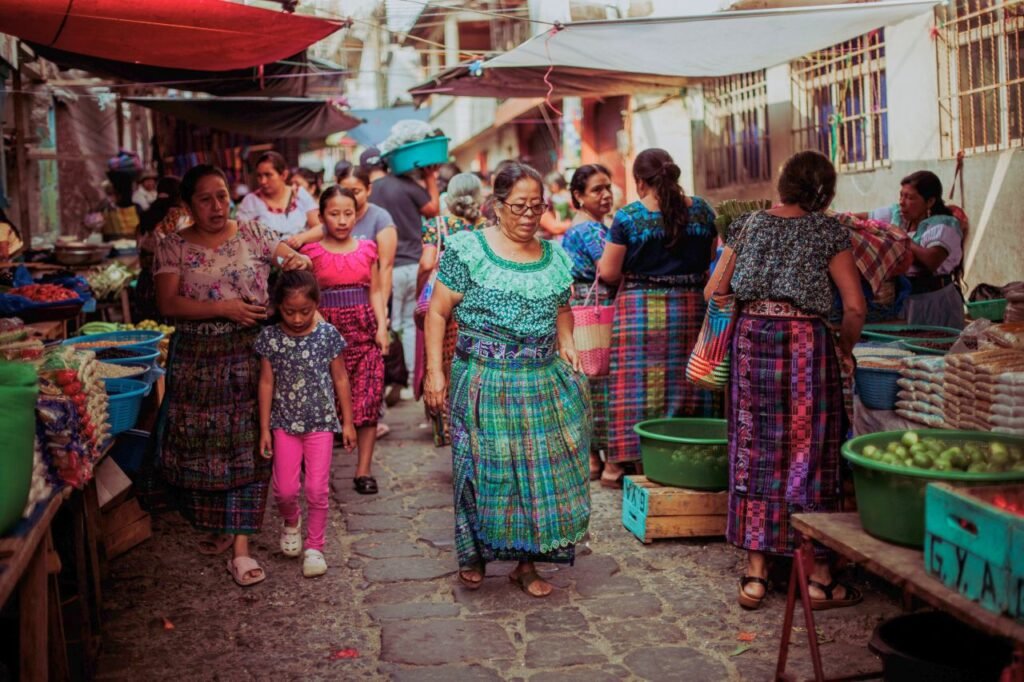 women and children in colorful traditional dresses at a bustling guatemalan market