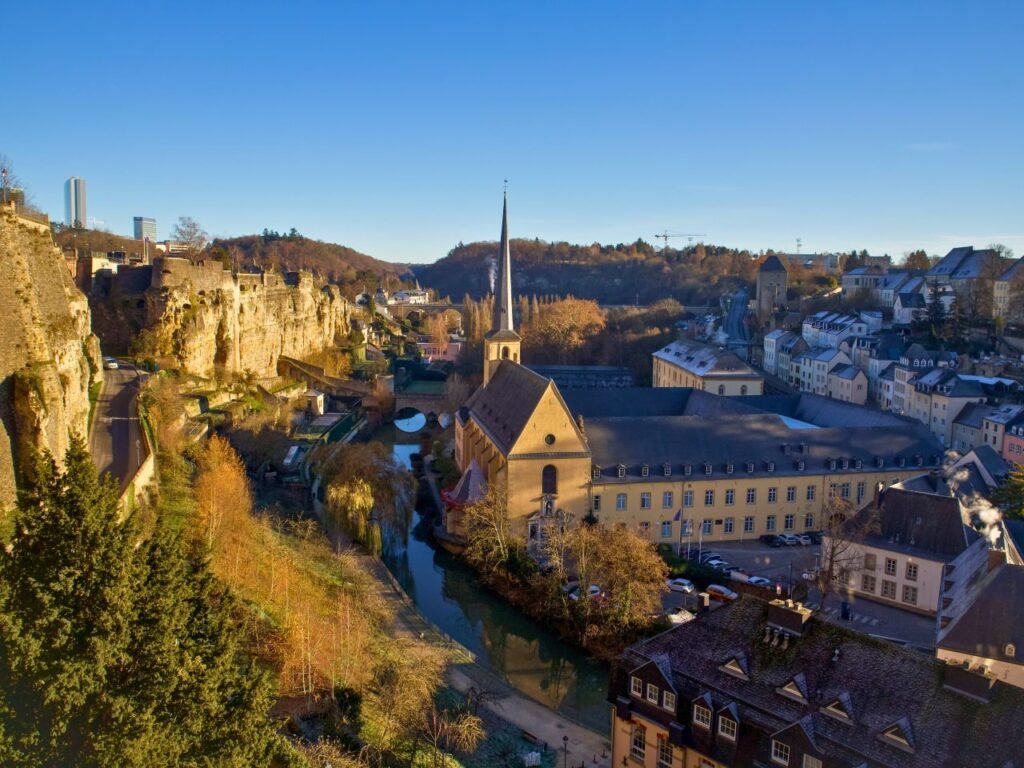 a picturesque view of luxembourg's cityscape featuring a historic church, canal, and blue sky luxembourg city, luxembourg