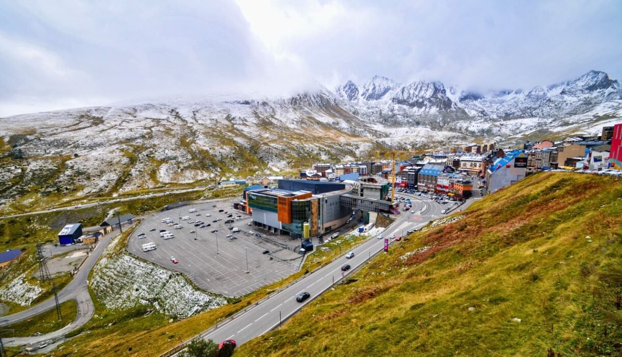 a snow dusted mountain town with parking lot and scenic roads on a clear day. andorra culture