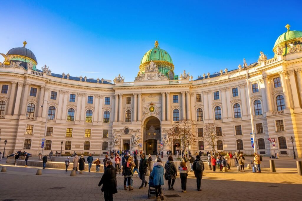 a vibrant scene outside hofburg palace in vienna with a crowd enjoying the sunny day vienna, vienna, austria