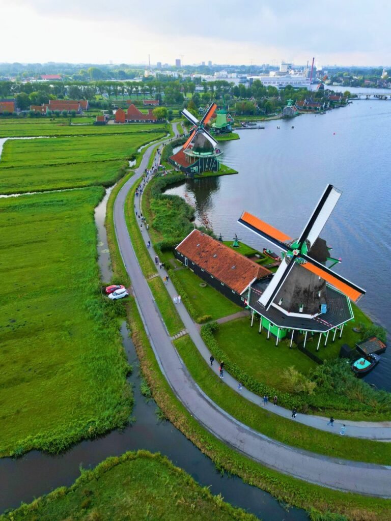 aerial perspective capturing the iconic windmills of zaanse schans along the river and fields amsterdam, nh, netherlands