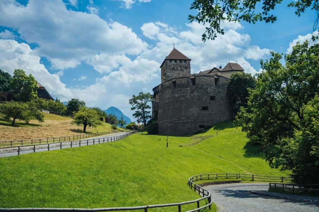 charming landscape featuring vaduz castle, lush green fields, and a bright blue sky vaduz, liechtenstein