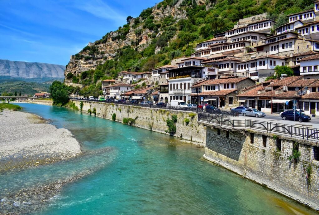 charming view of berat, albania showcasing traditional architecture alongside the osum river and scenic mountains.