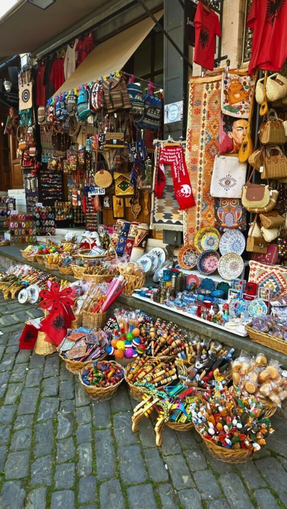 colorful outdoor market stall showcasing various traditional souvenirs and crafts on cobblestone street albania