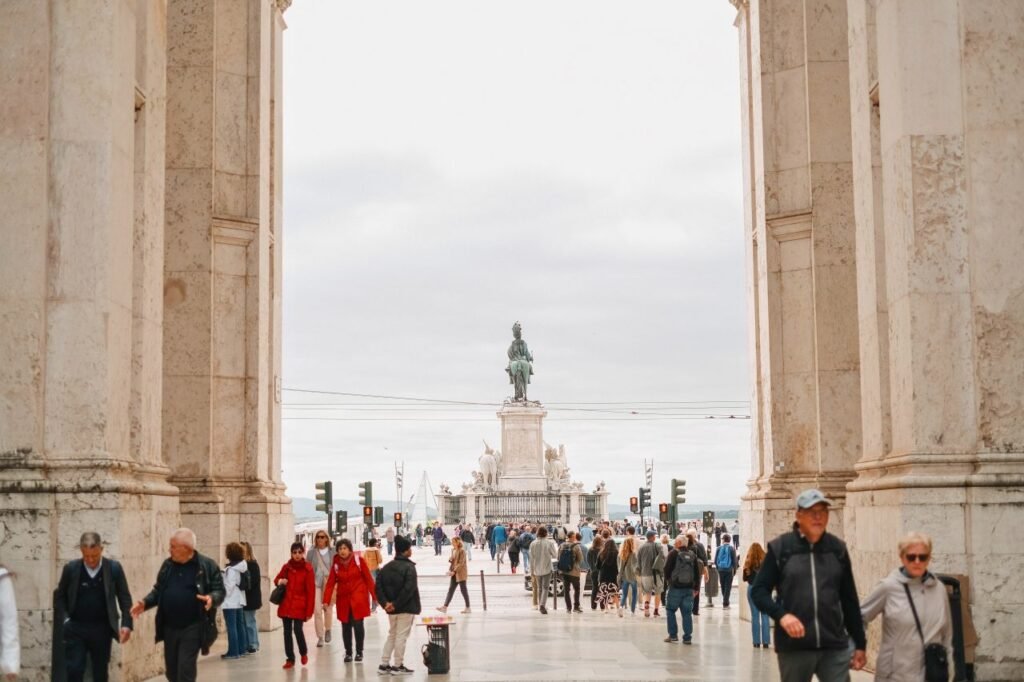 crowd of people walking through archway towards praça do comércio in lisbon lisbon, portugal