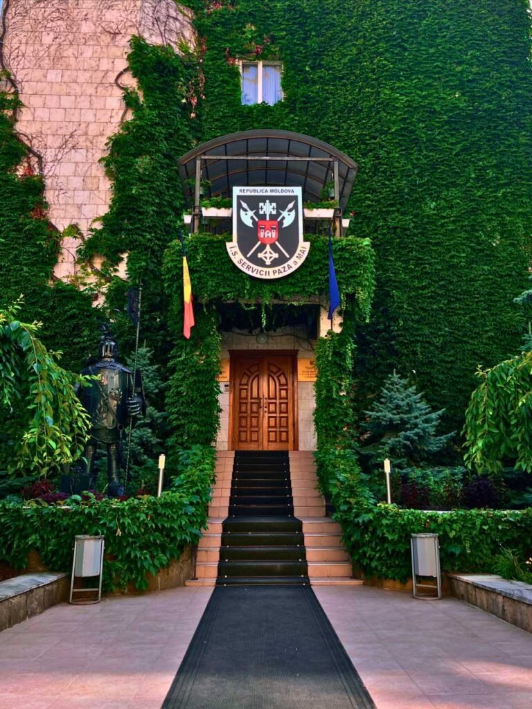 entrance to a historic building in chisinau, moldova, adorned with ivy and national flags