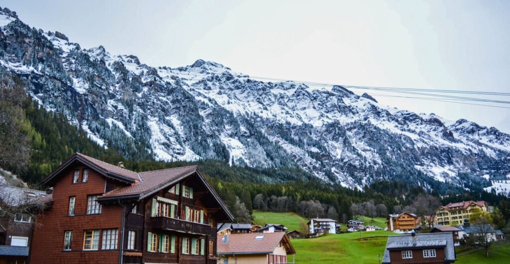 idyllic alpine village with traditional wooden houses beneath snow capped mountains switzerland
