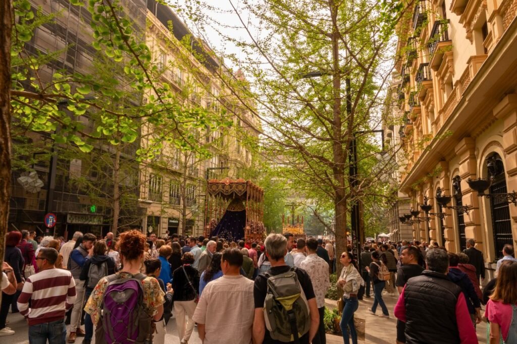 lively street festival in granada with a diverse crowd enjoying festivities among historic architecture spain