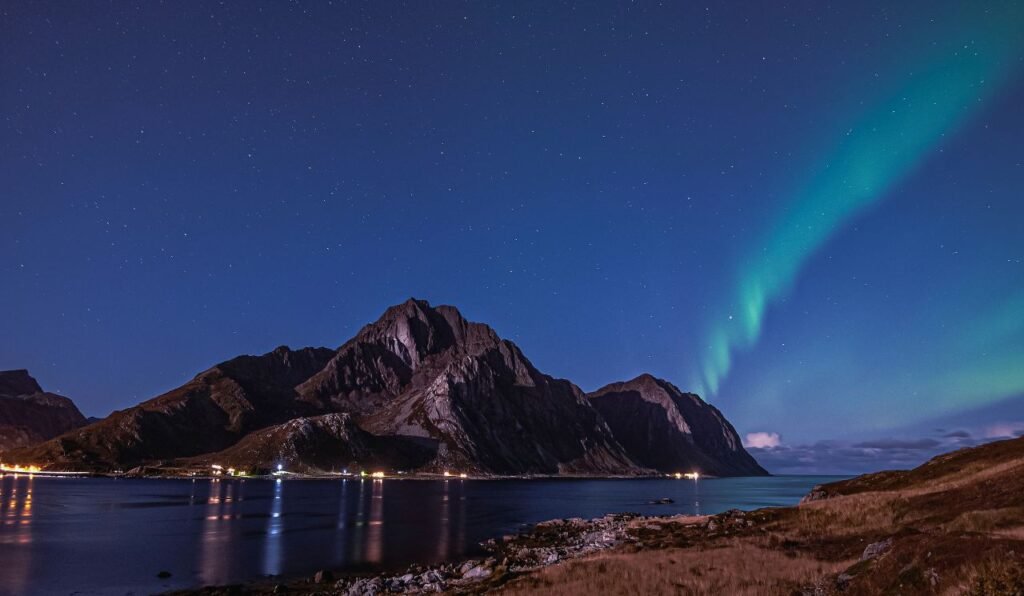 stunning view of the northern lights over the lofoten mountains and lake at night norway