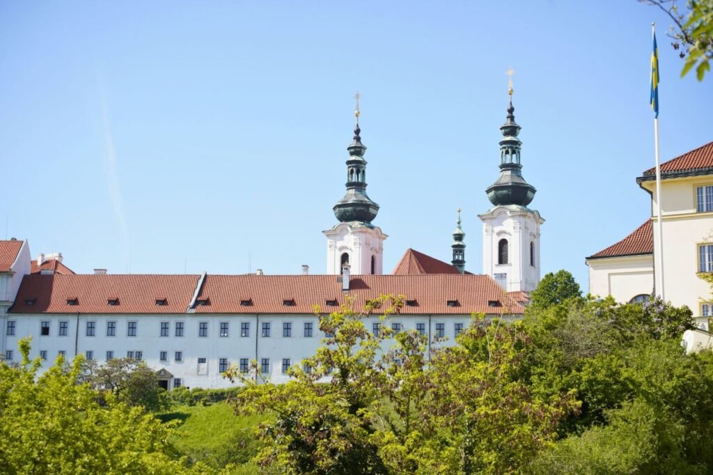 view of historic monastery with spires under clear blue sky in prague, czech republic.