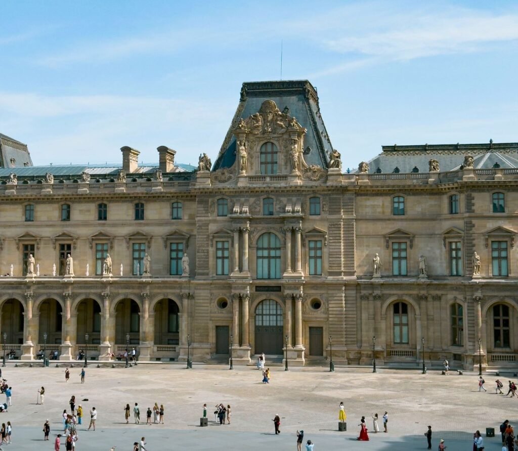 visitors explore the courtyard of the iconic louvre museum in paris on a sunny day paris, france