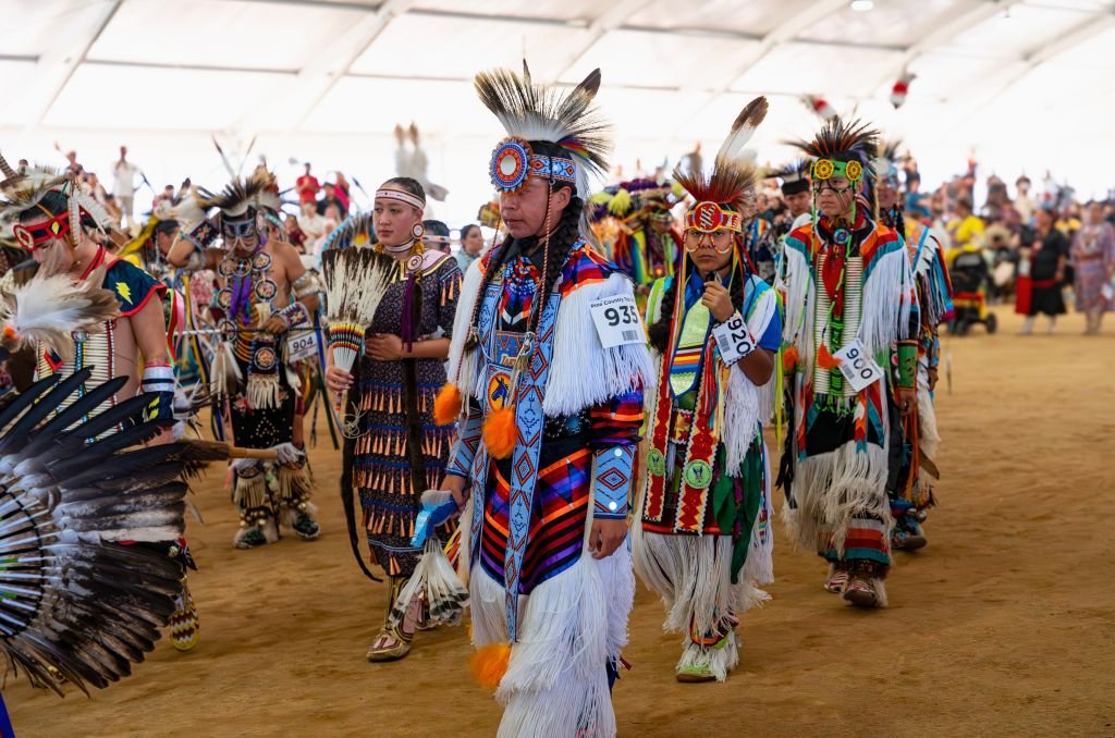 Traditions & Customs in the United States: A Tapestry of American Culture native american dancers in colorful traditional attire at a vibrant pow wow gathering united states
